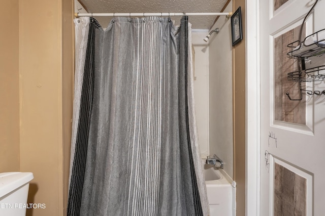 bathroom featuring shower / bath combo and a textured ceiling