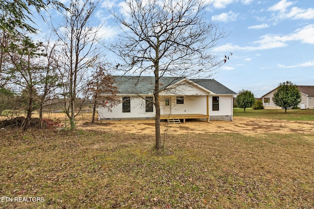 back of house featuring a lawn and a deck