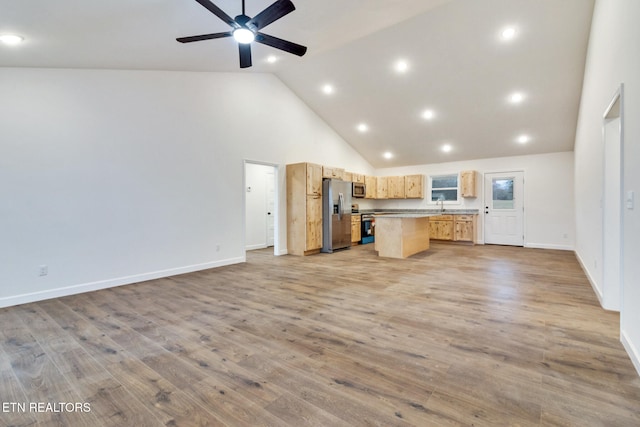 kitchen featuring a center island, light hardwood / wood-style floors, stainless steel appliances, and high vaulted ceiling