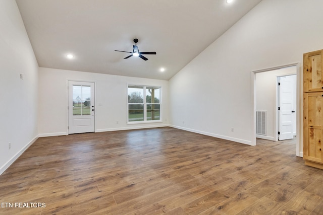 unfurnished living room with wood-type flooring, high vaulted ceiling, and ceiling fan