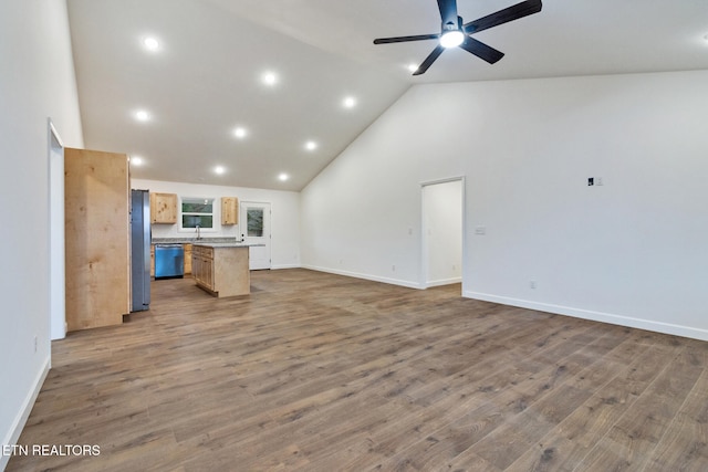 living room with ceiling fan, hardwood / wood-style floors, high vaulted ceiling, and sink