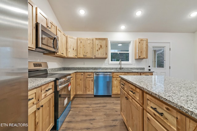 kitchen featuring light stone counters, stainless steel appliances, dark wood-type flooring, sink, and light brown cabinets