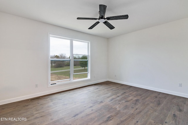 unfurnished room with ceiling fan and dark wood-type flooring