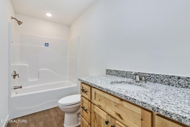 full bathroom with bathing tub / shower combination, vanity, wood-type flooring, and toilet