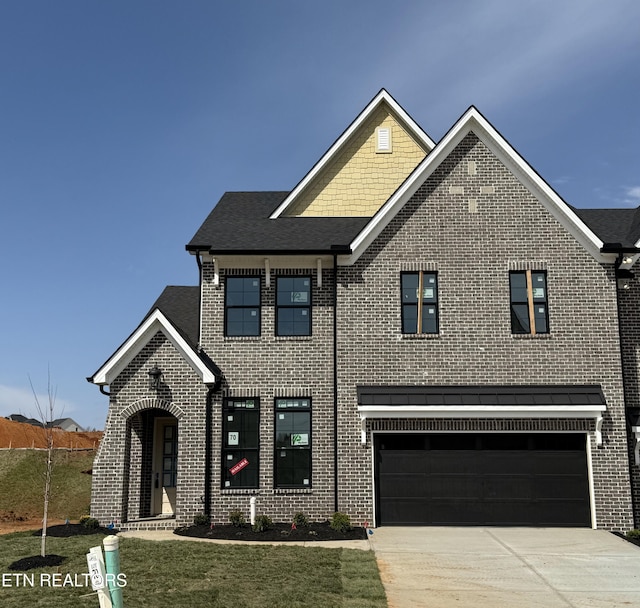 view of front of home featuring driveway, brick siding, and an attached garage