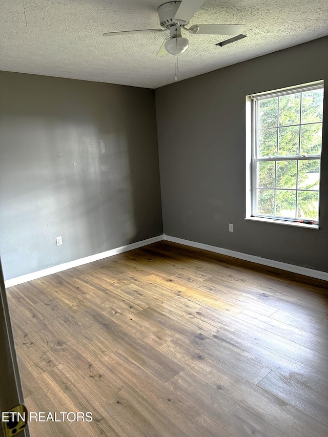 spare room featuring ceiling fan, a textured ceiling, and hardwood / wood-style floors