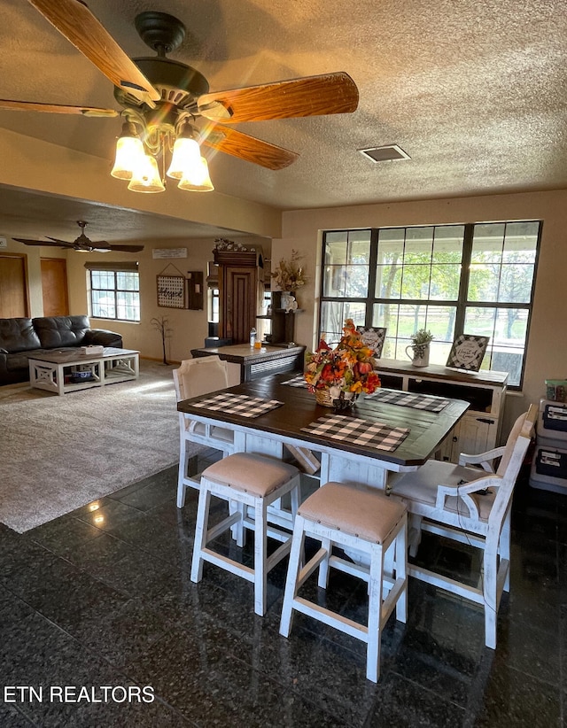 dining room featuring ceiling fan and a textured ceiling