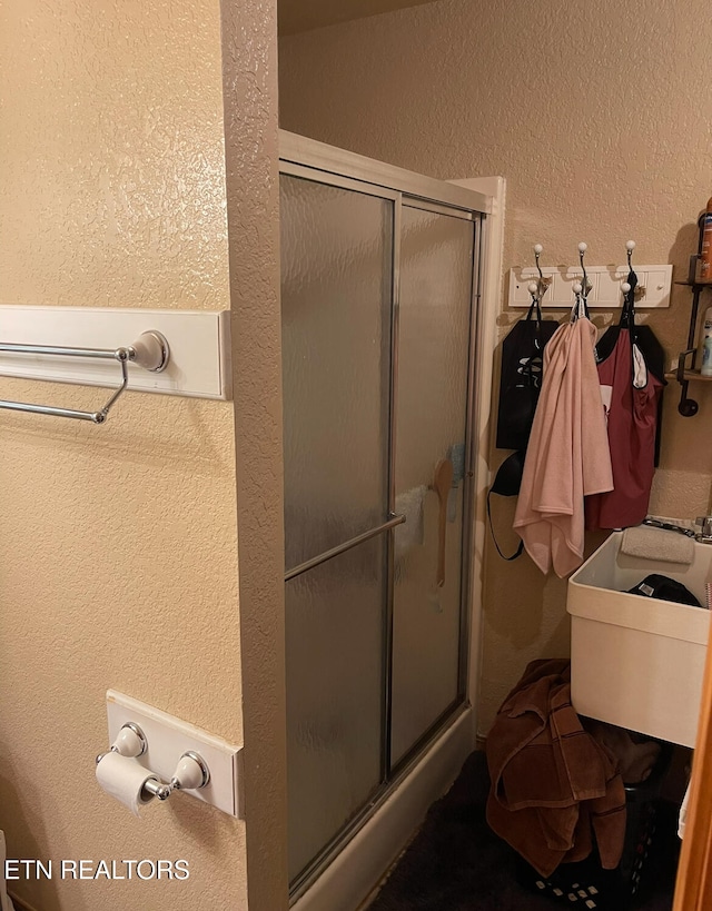 bathroom featuring a shower with door