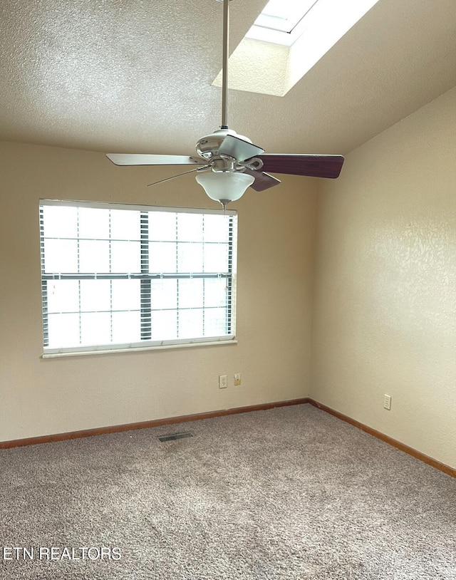 unfurnished room with plenty of natural light, a skylight, and carpet