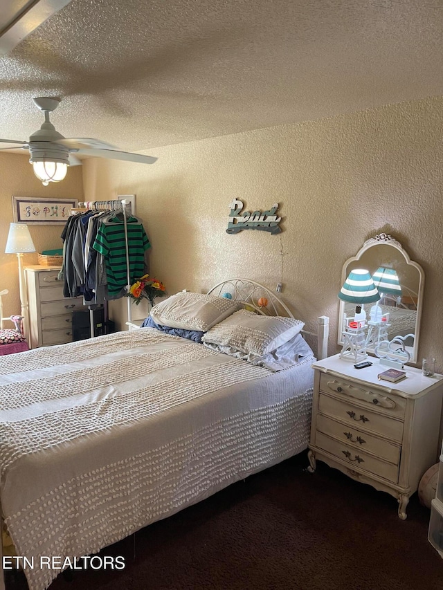 bedroom with ceiling fan and a textured ceiling