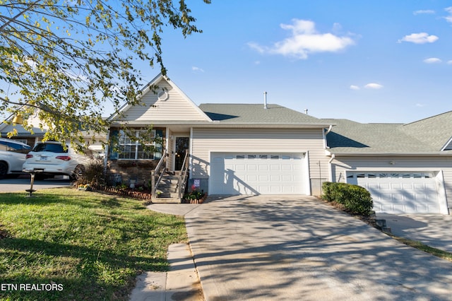 view of front of house featuring an attached garage, driveway, roof with shingles, and a front yard