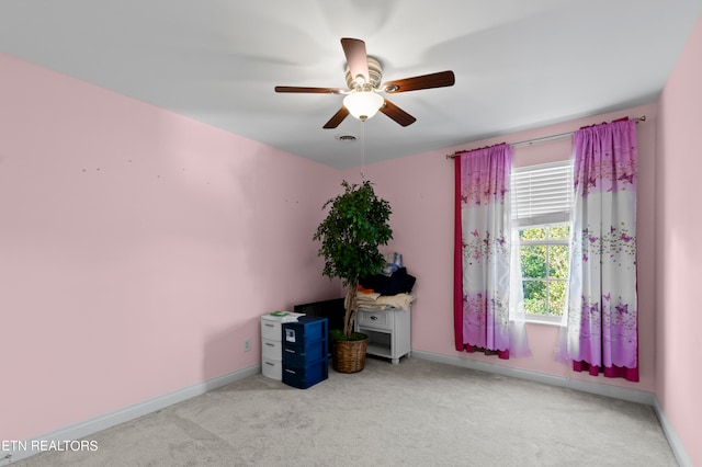 interior space with light carpet, ceiling fan, and baseboards