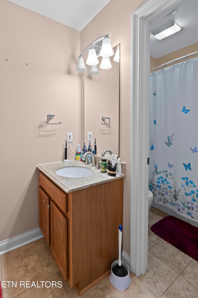 bathroom featuring baseboards, a shower with shower curtain, toilet, tile patterned floors, and vanity