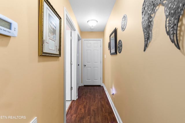 hallway featuring dark wood-style floors and baseboards