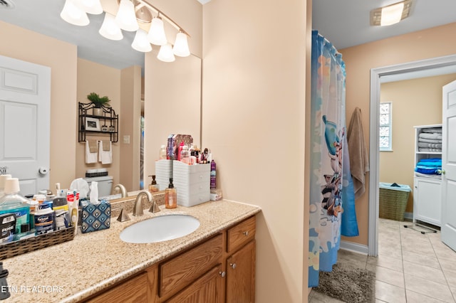 full bath with toilet, vanity, and tile patterned floors