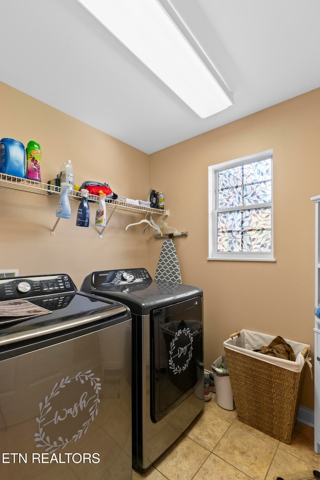 clothes washing area featuring laundry area, light tile patterned floors, and independent washer and dryer