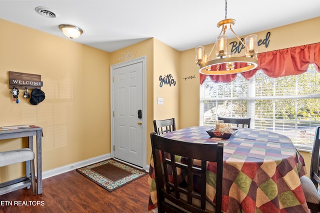 dining area featuring baseboards, dark wood-type flooring, visible vents, and an inviting chandelier