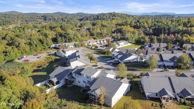 drone / aerial view featuring a residential view and a wooded view