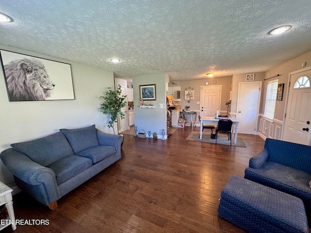 living room with dark hardwood / wood-style flooring and a textured ceiling