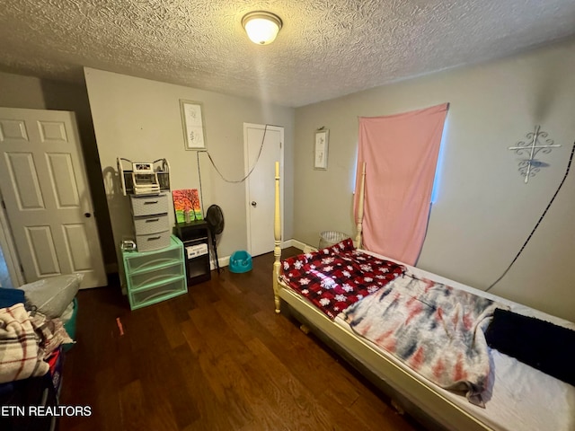 bedroom featuring a textured ceiling and dark hardwood / wood-style floors