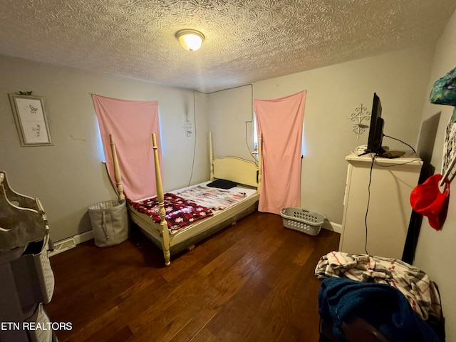 bedroom featuring dark wood-type flooring and a textured ceiling