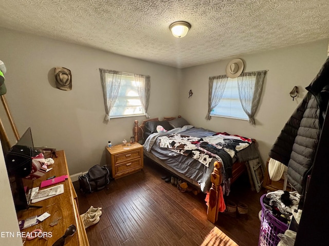 bedroom with a textured ceiling and dark hardwood / wood-style flooring