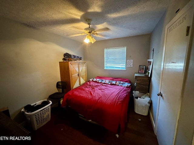 bedroom featuring a textured ceiling, dark wood-type flooring, and ceiling fan