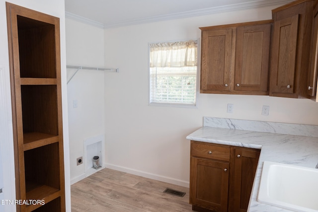 laundry area featuring cabinets, light hardwood / wood-style flooring, ornamental molding, and electric dryer hookup