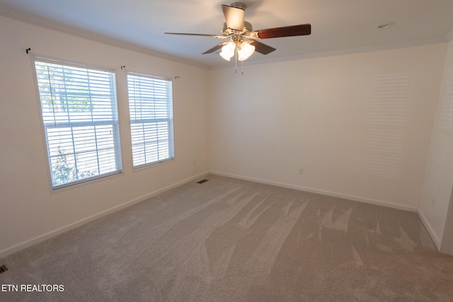 carpeted empty room with crown molding and ceiling fan