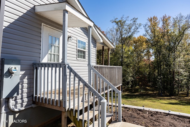 view of side of property featuring a deck and a lawn