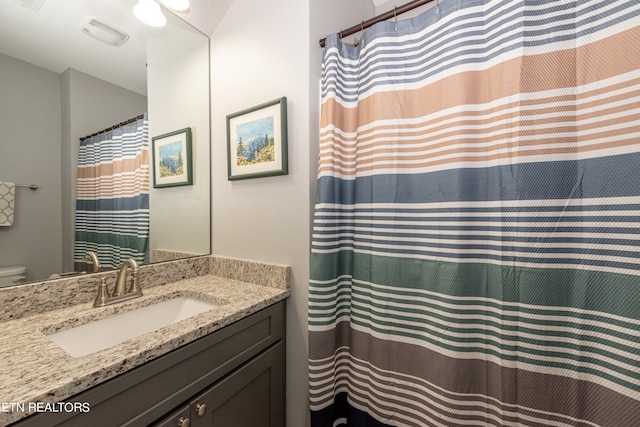 bathroom with vanity, toilet, and walk in shower