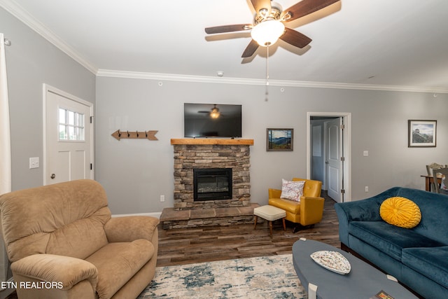 living room featuring crown molding, a stone fireplace, dark hardwood / wood-style floors, and ceiling fan