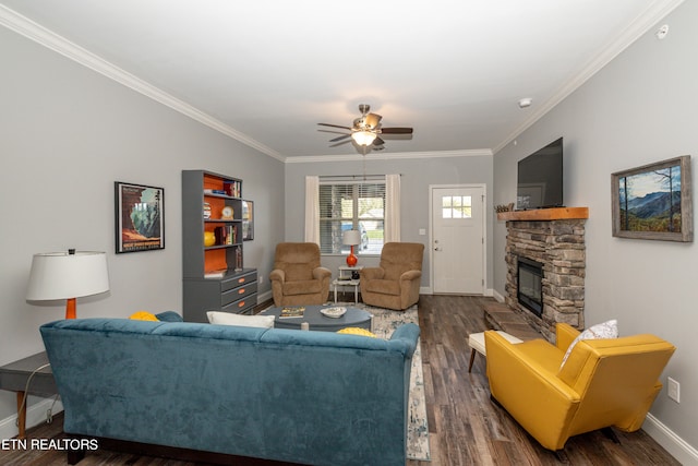 living room with a stone fireplace, crown molding, ceiling fan, and dark hardwood / wood-style flooring