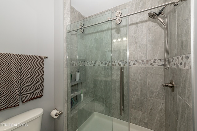 bathroom featuring toilet and an enclosed shower