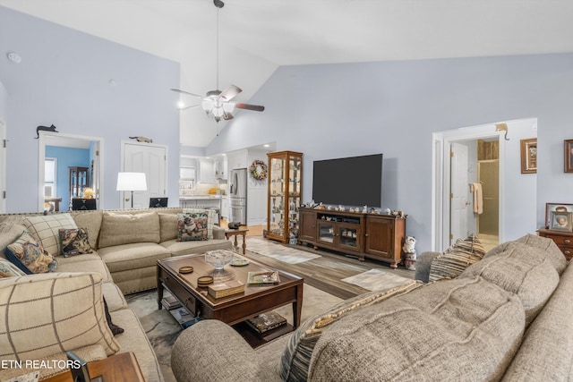 living room featuring light wood-type flooring, high vaulted ceiling, and ceiling fan