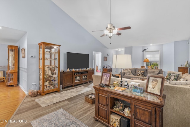 living room with ceiling fan, high vaulted ceiling, and light hardwood / wood-style flooring