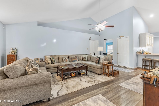 living room with ceiling fan, lofted ceiling, and hardwood / wood-style floors