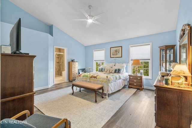 bedroom with connected bathroom, dark hardwood / wood-style floors, lofted ceiling, and ceiling fan