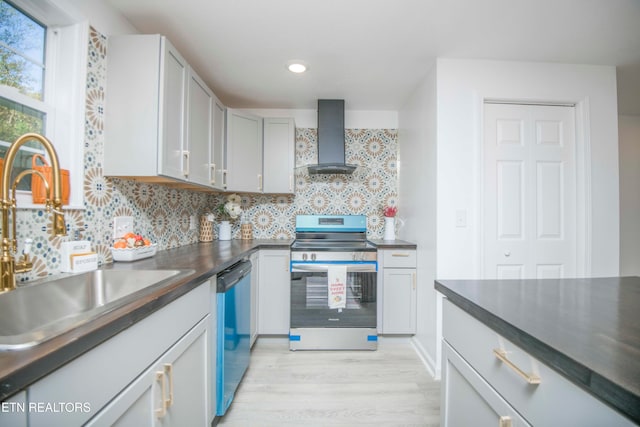 kitchen featuring wall chimney range hood, stainless steel appliances, sink, light wood-type flooring, and tasteful backsplash