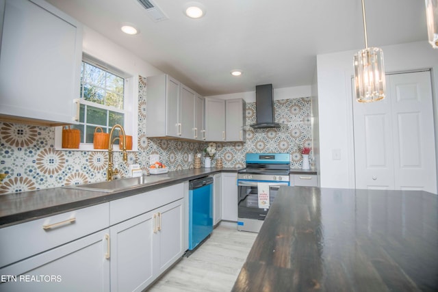 kitchen featuring backsplash, stainless steel appliances, sink, wall chimney exhaust hood, and decorative light fixtures