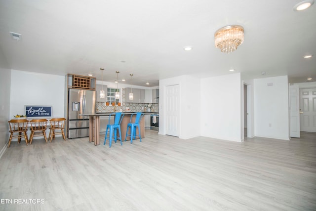 living room featuring a notable chandelier and light wood-type flooring