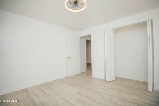 unfurnished bedroom with a closet and light wood-type flooring