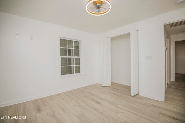 unfurnished room with light wood-type flooring and ceiling fan