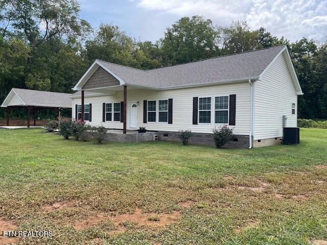 ranch-style home featuring central air condition unit and a front yard