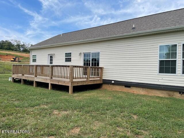 rear view of property featuring a deck and a lawn