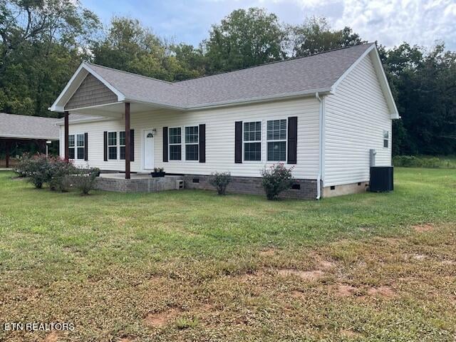 view of front of house with cooling unit and a front lawn