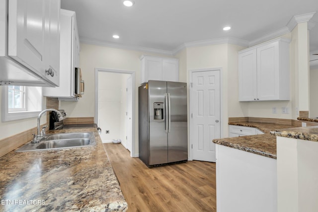 kitchen with white cabinets, light wood-type flooring, ornamental molding, sink, and stainless steel appliances