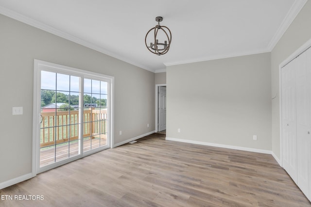 unfurnished room featuring light hardwood / wood-style flooring, a chandelier, and crown molding