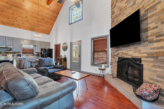 516 Clearwater Cir, Townsend, TN 37882 - living room featuring high vaulted ceiling, dark wood-type flooring, a fireplace, wooden ceiling, and a ceiling fan