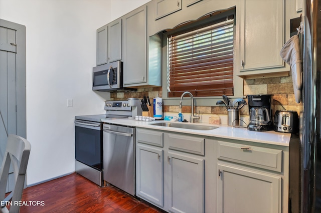 kitchen featuring dark hardwood / wood-style flooring, stainless steel appliances, gray cabinets, and sink